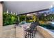 Outdoor kitchen with bar seating and lush landscaping at 3025 Oakmont Dr, Clearwater, FL 33761