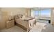 Bedroom with a comfortable bed, bedside tables, and a sliding glass door leading to a balcony with ocean views at 7000 Beach Plz # 706, St Pete Beach, FL 33706