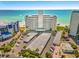 Aerial view of the building, parking area, and beach access at 7000 Beach Plz # 706, St Pete Beach, FL 33706