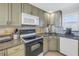 Kitchen with white appliances, including a smooth top range, microwave, and dishwasher, and speckled countertops at 7000 Beach Plz # 706, St Pete Beach, FL 33706