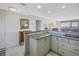 View of the kitchen highlighting the speckled countertops, light green cabinets, and breakfast bar at 7000 Beach Plz # 706, St Pete Beach, FL 33706