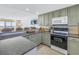 Compact kitchen featuring modern appliances, ample counter space, and light green cabinets at 7000 Beach Plz # 706, St Pete Beach, FL 33706
