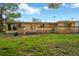 View of the home's exterior and grassy backyard at 703 W Sligh Ave, Tampa, FL 33604