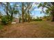Spacious, grassy backyard with mature trees and a view of the water at 703 W Sligh Ave, Tampa, FL 33604