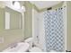 Bathroom with white tile, shower, sink, and decorative shower curtain at 703 W Sligh Ave, Tampa, FL 33604
