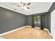 Empty bedroom featuring wood-style flooring, ceiling fan, and a large window at 703 W Sligh Ave, Tampa, FL 33604