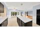 Spacious kitchen with island, dark cabinetry, and view to adjacent living area at 703 W Sligh Ave, Tampa, FL 33604