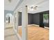 View of a living room with wood floors, ceiling fan, and dark painted walls through a glass wall at 703 W Sligh Ave, Tampa, FL 33604