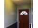 Hallway with a wooden door that has a decorative window at the top at 7116 Kingsbury Cir, Tampa, FL 33610