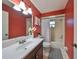 Clean bathroom with red walls, white vanity, and bathtub at 7471 35Th N St, Pinellas Park, FL 33781