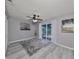 Bright bedroom with wood-look floors, ceiling fan, and sliding glass door to patio at 7471 35Th N St, Pinellas Park, FL 33781
