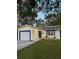 House exterior showcasing a white garage door, blue accents, and a well-maintained lawn at 7471 35Th N St, Pinellas Park, FL 33781
