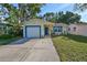 Newly painted yellow house with blue trim, a single car garage, and well-maintained lawn at 7471 35Th N St, Pinellas Park, FL 33781