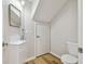 Small bathroom with white vanity and toilet, mirror, and wood-look flooring at 10952 Brickside Ct, Riverview, FL 33579