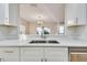 White kitchen with stainless steel appliances, ample counter space, and pass-through window to the dining area at 10952 Brickside Ct, Riverview, FL 33579