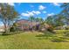 Expansive backyard featuring a screened lanai, lush lawn, and mature landscaping with palm trees at 1160 Darlington Oak Ne Dr, St Petersburg, FL 33703