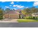 Tan house with tile roof, three-car garage, and lush landscaping at 1160 Darlington Oak Ne Dr, St Petersburg, FL 33703