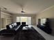 Living room with black sectional sofa, ceiling fan, and sliding glass doors at 1420 Water View W Dr # 203, Largo, FL 33771