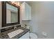 Bathroom with dark granite countertop, single vanity, and black-framed mirror at 150 Brent Cir, Oldsmar, FL 34677