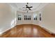 Bright, empty bedroom with hardwood floors, ceiling fan, and large windows with plantation shutters at 1533 Emerald Dunes Dr, Sun City Center, FL 33573