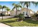 Single-story home with a three-car garage, palm trees, and a well-manicured lawn at 1533 Emerald Dunes Dr, Sun City Center, FL 33573