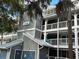 Three-story building with balconies, Spanish moss, and a metal roof at 2533 Dolly Bay Dr # 101, Palm Harbor, FL 34684