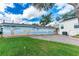 Backyard view of the home with a unique mural, brick patio, and green grass at 37226 Lakewood Dr, Zephyrhills, FL 33542