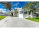 Front exterior of a single-story home with a carport, stairs to the entrance, and a large driveway at 37226 Lakewood Dr, Zephyrhills, FL 33542