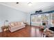 Living room with pink couch, wood floors, armchairs, and natural light at 37226 Lakewood Dr, Zephyrhills, FL 33542