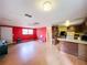 Spacious living room features laminate wood floors and a partially painted red wall at 5960 Tower Rd, Land O Lakes, FL 34638