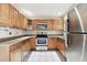 Kitchen featuring wood cabinets, stainless steel appliances, and tile flooring at 7604 Glades Ct, Temple Terrace, FL 33637