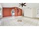 Living room with tile flooring, ceiling fan, and a burnt orange accent wall at 7604 Glades Ct, Temple Terrace, FL 33637