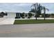 Newly renovated home with a modern exterior, featuring a lush lawn and driveway at 87 Rotonda Cir, Rotonda West, FL 33947