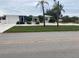 Newly renovated home with a modern exterior, featuring a lush lawn and driveway at 87 Rotonda Cir, Rotonda West, FL 33947