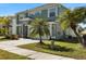 Two-story house with green exterior, palm trees, and a two-car garage at 11351 Callaway Pond Dr, Riverview, FL 33579