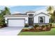 Attractive single-story home with a two-car garage, landscaping, and a welcoming entryway at 12067 Kingsley Trl, Parrish, FL 34219