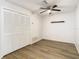 Bright bedroom with closet, ceiling fan, and wood-look floors at 12914 Fairway Dr # A, Hudson, FL 34667