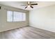 Bedroom featuring wood-look floors, ceiling fan, and a window with blinds at 12914 Fairway Dr # A, Hudson, FL 34667