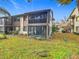 Exterior view of a two-story condo with a screened porch and landscaped yard at 12914 Fairway Dr # A, Hudson, FL 34667