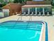 Community pool with steps, handrails, and a shaded area with lounge chairs at 12914 Fairway Dr # A, Hudson, FL 34667