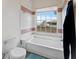 Bathroom with white bathtub, toilet, and window view of backyard at 13346 Carter Ave, Port Charlotte, FL 33981