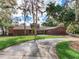 Home exterior featuring a well-maintained lawn, a long driveway, and mature landscaping at 18120 Wayne Rd, Odessa, FL 33556