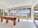Game room with a pool table, large windows and sliding door offering lake views at 18120 Wayne Rd, Odessa, FL 33556