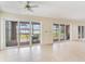 Bright living room with tile floors, ceiling fan and sliding glass doors leading to outdoor patio with lake view at 18120 Wayne Rd, Odessa, FL 33556