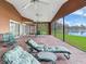 Enjoy lakefront living on this screened porch with seating and dining areas at 18120 Wayne Rd, Odessa, FL 33556