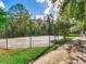 Tennis court with surrounding trees and walkway at 18120 Wayne Rd, Odessa, FL 33556