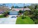 Charming single-Gathering home features lush landscaping, bright turquoise exterior, and a two-car garage at 2993 W Vina Del Mar Blvd, St Pete Beach, FL 33706