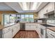 Bright kitchen featuring white cabinetry, tiled backsplash, and stainless steel appliances at 2993 W Vina Del Mar Blvd, St Pete Beach, FL 33706