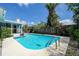 Inviting swimming pool with tropical palms, lush landscaping, and a comfortable seating area at 2993 W Vina Del Mar Blvd, St Pete Beach, FL 33706