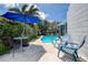 Inviting backyard pool area, perfect for relaxation and entertainment with chairs and umbrella at 2993 W Vina Del Mar Blvd, St Pete Beach, FL 33706